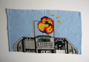 An embroidery by artist and sculptor G. Alexandridis, depicting a fighter plane cockpit during combat. Ένα κέντημα από τον εικαστικό και γλύπτη Γιώργο Αλεξανδρίδη.